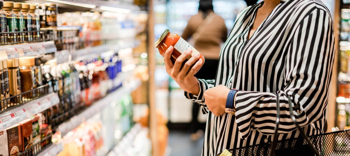 La etiqueta de un producto influye de manera significativa en la decisión de compra. Consumidora evaluando etiqueta promocional de producto